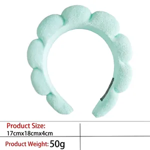 Macro shot of a light mint green puffy headband showing plush fabric texture and soft padding