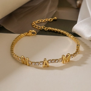 Macro shot of 18K gold plated MAM letter bracelet with sparkling cubic zirconia inlay