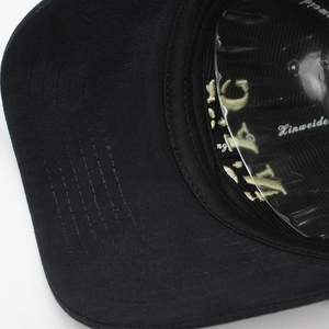Vue macro des coutures parallèles sur la visière de la casquette de baseball noire en coton