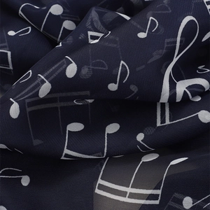 Macro shot of navy chiffon scarf with white music note prints showing sheer texture