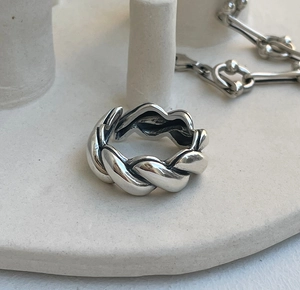 Macro view of wide twisted braid texture on a 925 sterling silver minimalist ring