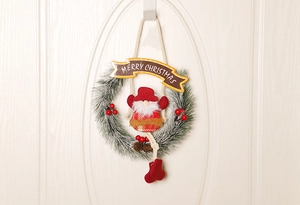 Detail eines Weihnachtskranzes mit Weihnachtsmann, Tannennadeln, roten Beeren und Merry Christmas
