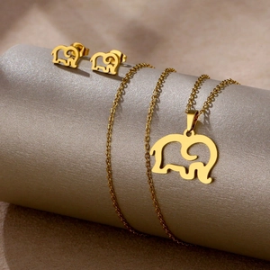 Macro view of gold elephant necklace and earrings jewelry set on a display stand