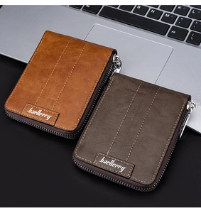 Close-up of brown and dark grey RFID men's wallets on a laptop in a lifestyle setting