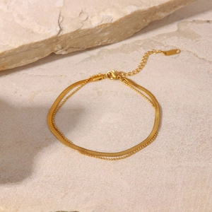Detail of 18K gold double layer anklet featuring flat snake chain and small bead chain