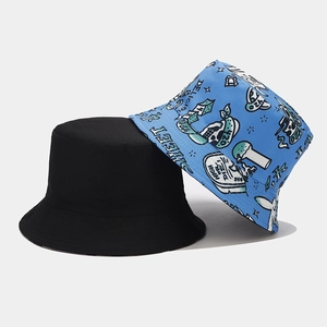 Detail of reversible bucket hats in solid black and blue graffiti pattern canvas fabric