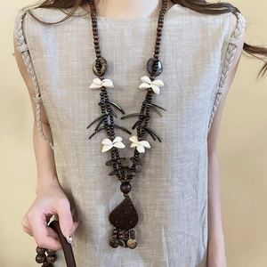 Detailed close-up of a handmade ethnic style necklace with wood beads and shell flower