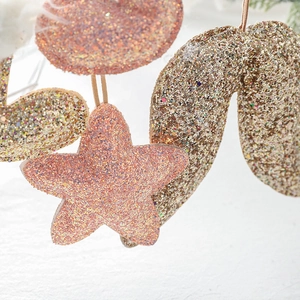 Glittery rose gold star and wing Christmas ornaments for festive holiday atmosphere decoration