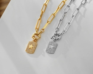 Detail view of gold and silver paperclip chains with micro-pave star heart pendants