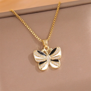 Elegante collana a farfalla dorata con smalto bianco e nero e dettagli brillanti