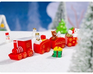 Detailed close-up of a miniature Christmas train set featuring resin snowmen and bear figures