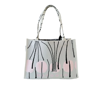 Chic knitted tote bag with artistic black lines and pink dots on a cream background