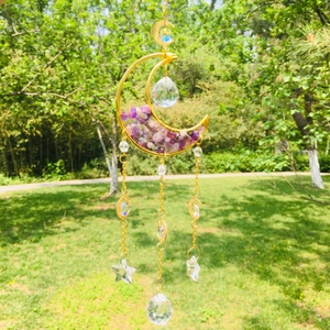 Close-up of golden moon sun catcher with purple amethyst stones and crystal ball pendant