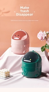 Detailed view of pink and green dinosaur-shaped mini desktop bins with flip-top lids