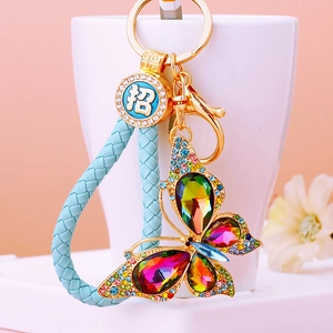 Detail of colorful crystal butterfly keychain with blue braided strap and gold clasp