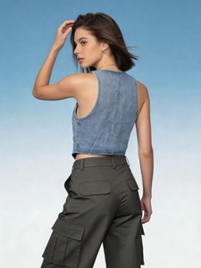 Detailed back view of a slim blue denim vest paired with military green cargo pants