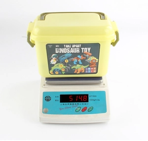 Detail of yellow take-apart dinosaur toy set in a portable storage bucket for toddlers