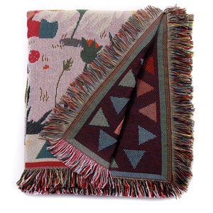 Macro detail of bohemian woven blanket showcasing intricate floral patterns and colorful tassels