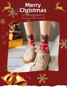 Detail of red Christmas socks featuring 3D plush bear ears and festive elk patterns