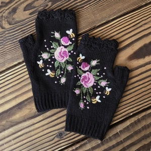 Detail of bee and rose embroidery on black knitted fingerless gloves for women