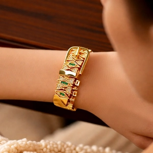 Detail of 18k gold plated geometric buckle bracelet with green gemstone and small diamonds
