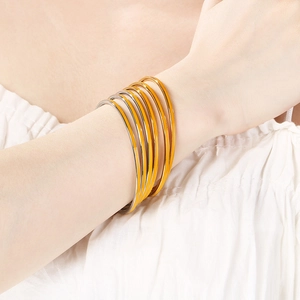 Detail of stacked 3mm stainless steel bangles in bright yellow and silver finishes