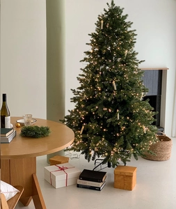 Cozy Christmas tree with warm candle lights and LED string lights on a rustic table