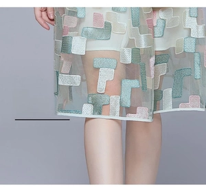 Detailed close-up of intricate geometric embroidery on a translucent mesh fairy dress skirt