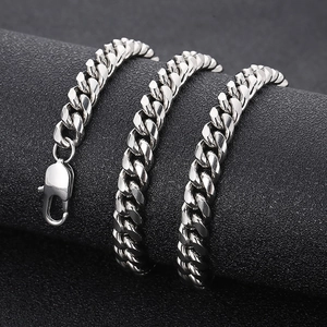 Close-up of a polished silver Cuban link chain necklace with lobster clasp on a black stand