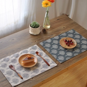 Linen tea towel with tree patterns in dark blue and cream white on a wooden table