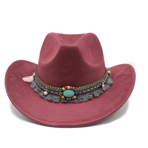 Détail d'un chapeau de cowboy bordeaux en suédine avec pierre turquoise et décoration à gland