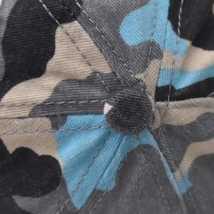 Gros plan du motif camouflage et des coutures de qualité sur une casquette de baseball en coton
