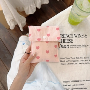 Close-up of pink canvas pouch with red hearts and secure white snap button closure