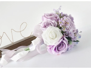 Detailed view of purple silk roses bridal bouquet with long satin ribbons and greenery