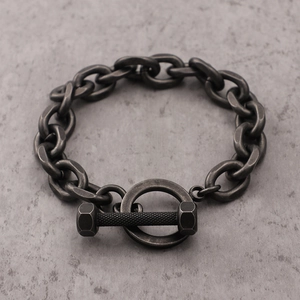 Macro detail of industrial style chain bracelet featuring retro barbell bolt clasp