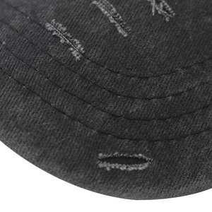Dettaglio della visiera consumata e delle cuciture su un cappellino da baseball in cotone nero