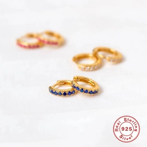 Close-up of S925 sterling silver huggie earrings with blue, white and pink zircon gems