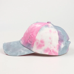Close-up of pink and blue tie-dye cotton baseball cap with distressed torn details