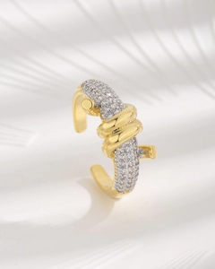Macro detail of golden twist knot ring with pave-set white cubic zirconia stones