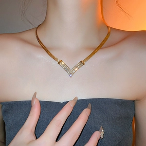 Elegant gold plated V-shaped necklace with sparkling crystals on model's neck