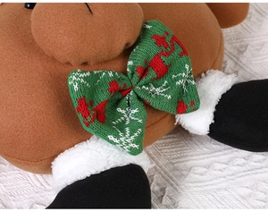Close-up of brown plush reindeer toy with green knitted bow and detailed soft texture
