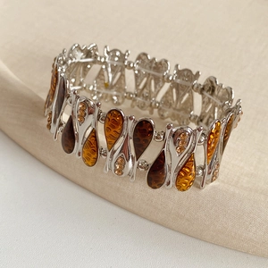 Close-up of vintage teardrop chain bracelet with amber resin and yellow rhinestones