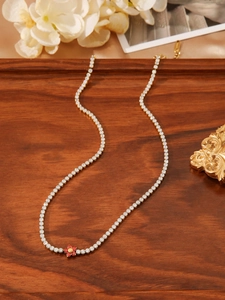 Detailed macro view of a red flower pendant on a sparkling zircon paved necklace