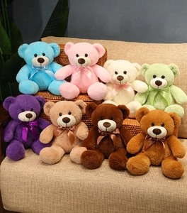 Detailed collection of colorful teddy bear plush toys with ribbons on a cozy sofa