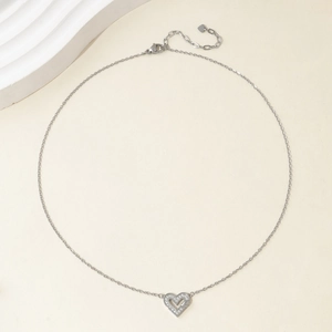 Close-up of silver heart pendant necklace with fine stones on a delicate O-chain