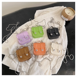 Détails des mini sacs à bandoulière en six couleurs sur un tissu blanc doux