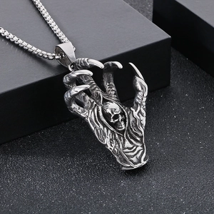 Macro view of gothic silver beast claw clutching a skull pendant with box chain
