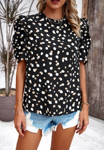 Detail der kurzen Puffärmel an diesem schwarz-beigen Polka-Dot-Oberteil für Damen