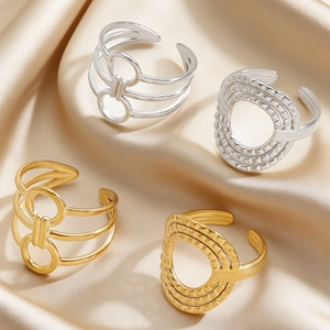 Detail view of geometric adjustable rings with layered lines on champagne silk fabric