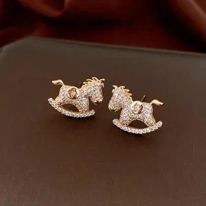 Golden rocking horse stud earrings with sparkling white zircon stones and starry detail